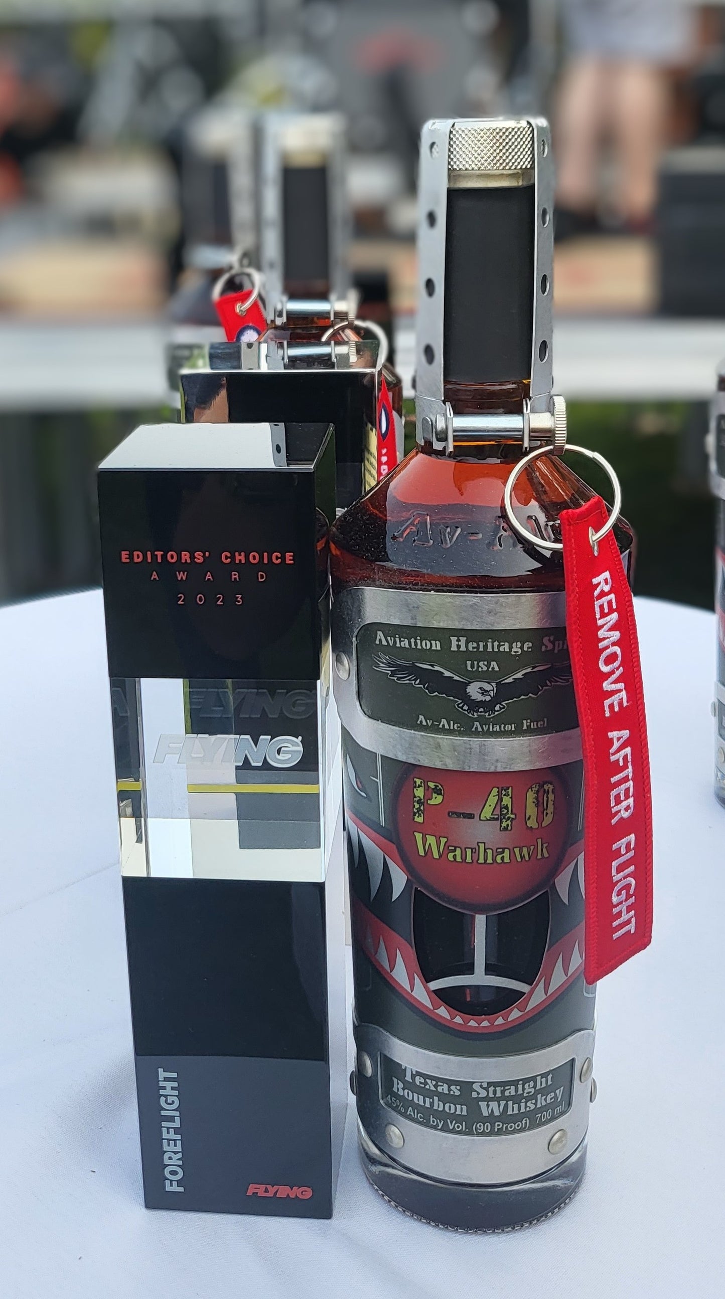 Special Tribute Spirits' "Shark Mouth" P-40 Warhawk decanter positioned next to its 2023 Editors' Choice Award from FLYING Magazine. 