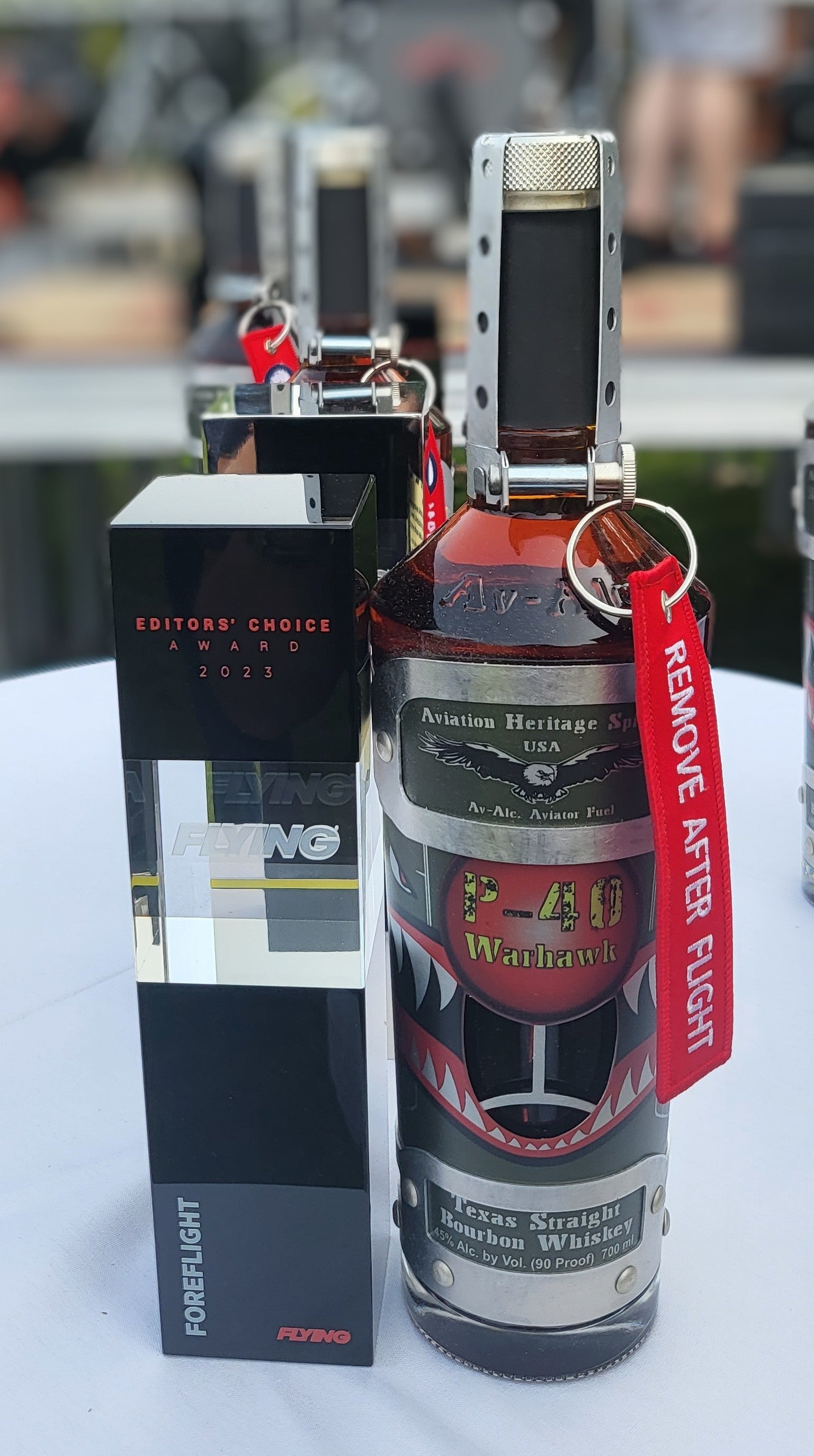 Special Tribute Spirits' "Shark Mouth" P-40 Warhawk decanter positioned next to its 2023 Editors' Choice Award from FLYING Magazine. 